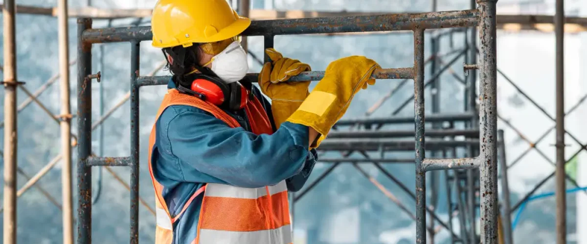 Homem carregando andaimes de construção civil